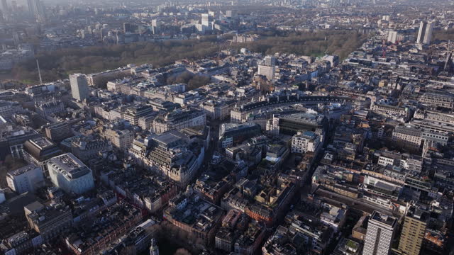Dolly back pan up aerial shot over central London Soho and Belgravia