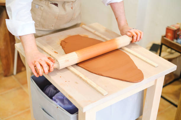 istock Woman smoothing the kneaded mud with a rolling pin 2063165078