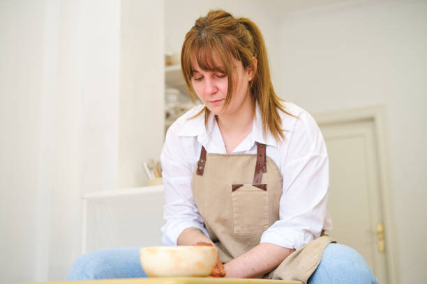 istock Concentrated woman molding clay using pottery wheel 2063165105