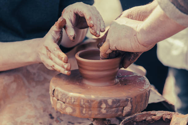 istock hands of a potter, creating an earthen jar on a pottery wheel 2063187324