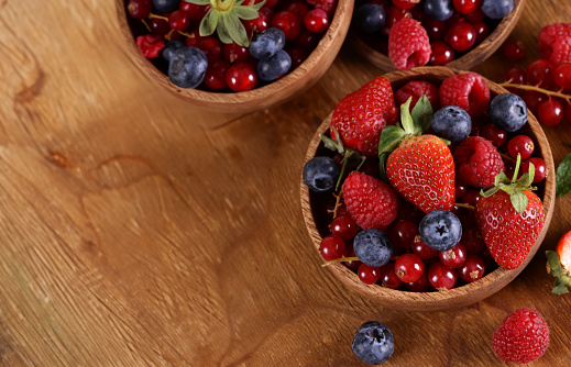fresh berries raspberries strawberries currants on a wooden table