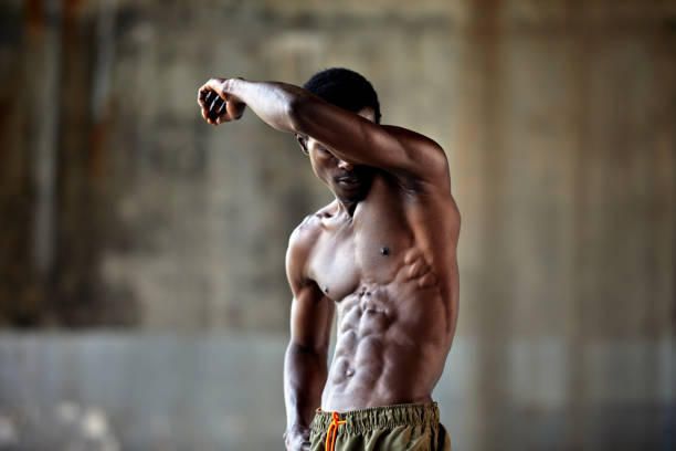 An African bodybuilder is intensely exercising in the gym, sweating profusely as they build strong muscles and strive for a healthy lifestyle.