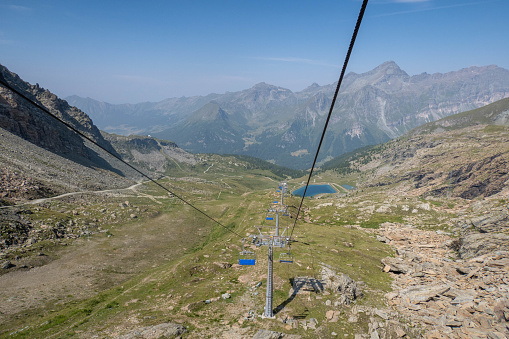 A breathtaking summer vista in the Swiss Alps unveils lush green mountains and picturesque valleys, harmonizing nature's beauty in a captivating alpine landscape.