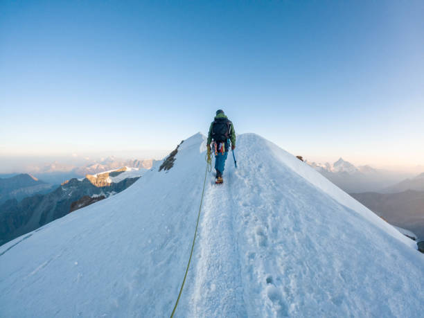 istock Alpinist aiming for the summit on snowy ridge 2063222422