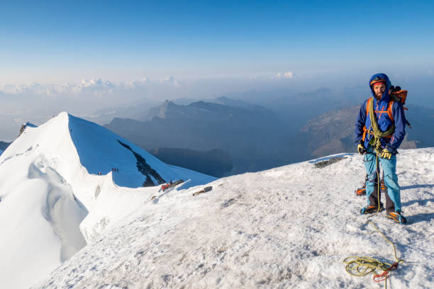 An intrepid alpinist ascends a snowy ridge with unwavering determination, pushing towards the summit in the pristine and challenging terrain of high-altitude adventure.