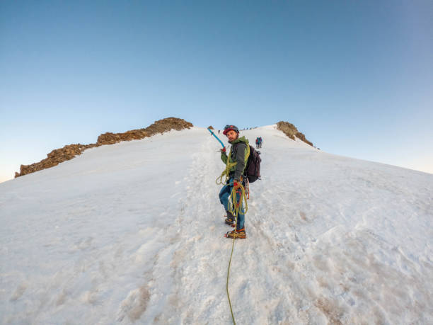 istock Alpinist aiming for the summit on snowy ridge 2063223486