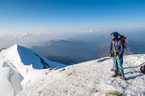An intrepid alpinist ascends a snowy ridge with unwavering determination, pushing towards the summit in the pristine and challenging terrain of high-altitude adventure.