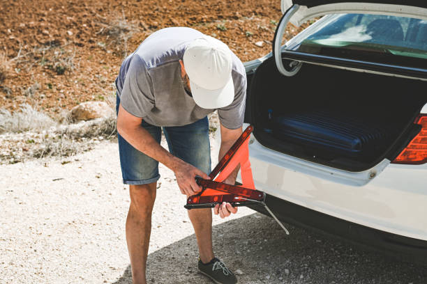 man stands by a broken car - stranded travel people traveling disappointment - fotografias e filmes do acervo