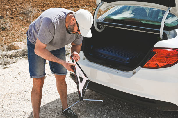 man stands by a broken car - stranded travel people traveling disappointment - fotografias e filmes do acervo