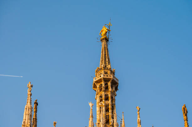 statues and details of the Milan cathedral external with a blue sky in the background