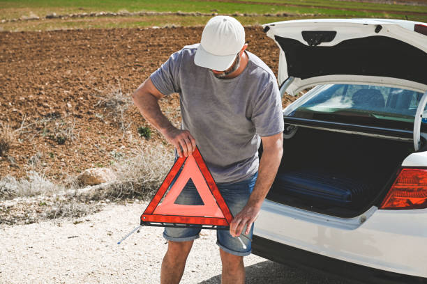 man stands by a broken car - stranded travel people traveling disappointment - fotografias e filmes do acervo