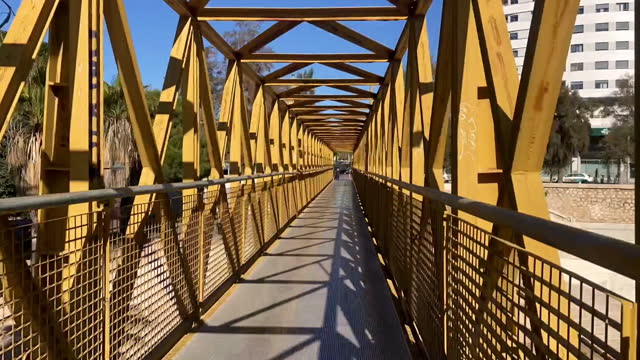 Walking along metallic suspended bridge time lapse