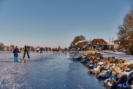 Tienhoven, Netherlands, February 12, 2021; Woman tries to learn to skate on the ice with a chair.