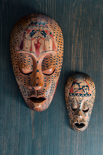 Two african masks on a wooden wall background. Close up