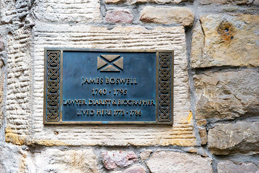 Royal Mile, Edinburgh, Scotland, August 2023. This is the Royal Mile early morning during the Edinburgh Fringe Festival. This set of buildings has a memorial plaque for James Boswell, lawyer, Diarist and Biographer, who lived here 1773-1786.