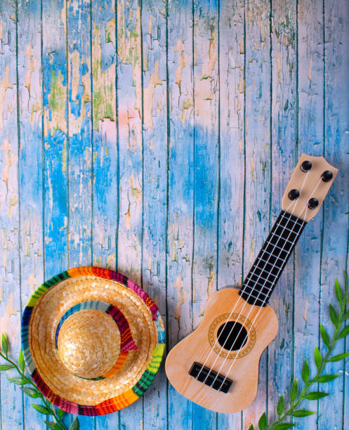 Mexican composition with copy space. Guitar and sombrero hat on blue background. Stereotypical attributes of Mexican culture. Celebrating Cinco de Mayo