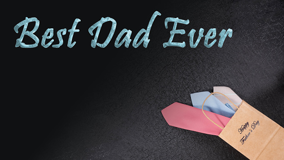 Father's Day Concept.  Black textured background with a brown gift bag with neckties spilling out.  Text caption, Best Dad Ever.