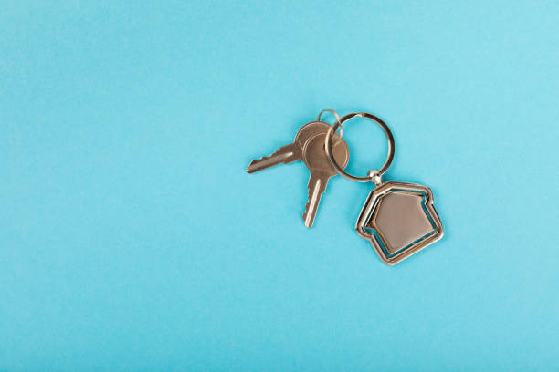 Keychain with key ring isolated on a colored background. Concepts for real estate and moving home or renting property. Buying a property. Mock-up keychain.Copy space.