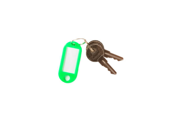 Person presenting a house key with a bright green keychain, focus on key in hand.