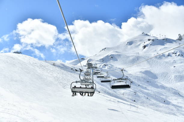 People going up on the mountain with ski lift by winter