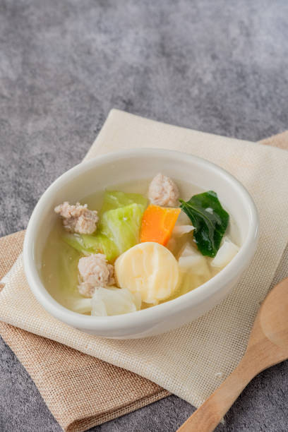 Soup with egg tofu and minced pork in a white oval cup vertical photo Soup with egg tofu and minced pork in a white oval cup, copy sapce for text. ugly soup stock pictures, royalty-free photos & images