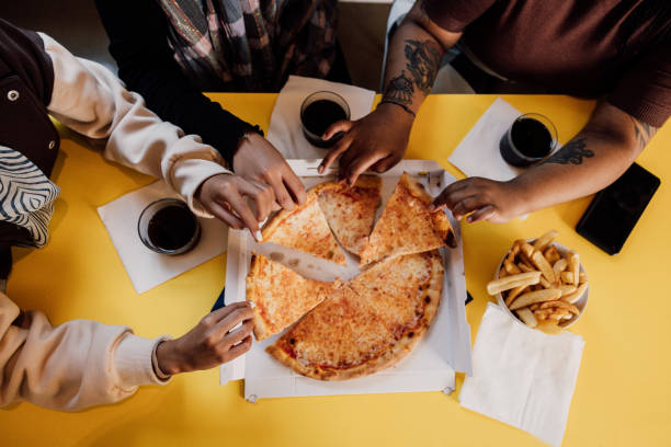 istock Three friends eating pizza slices 2063299796