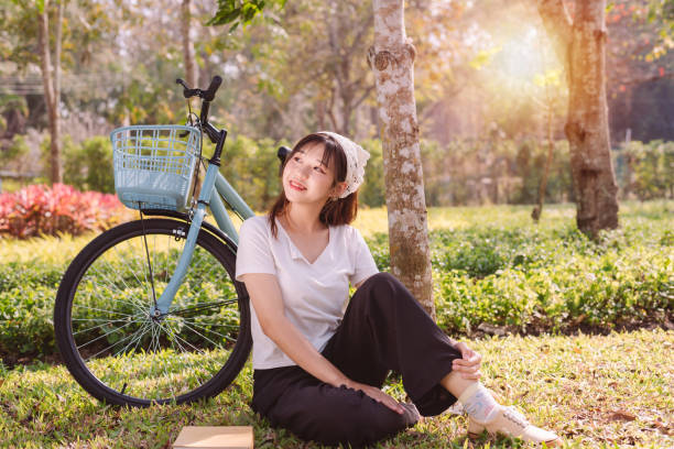 person with bike in nature park in vacation and mental wellbeing. - mental health women asian ethnicity bicycle photos et images de collection