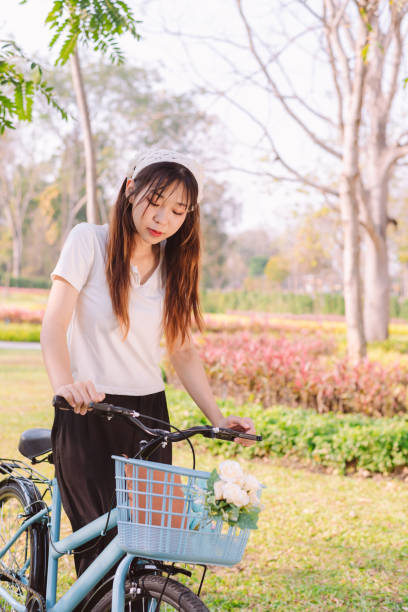 person with bike in nature park in vacation and mental wellbeing. - mental health women asian ethnicity bicycle 뉴스 사진 이미지