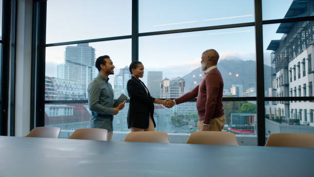 istock Meeting, handshake and business people in office for teamwork, agreement and b2b networking. Corporate, diversity and men and women shaking hands for welcome, thank you and partnership by window 2063318121