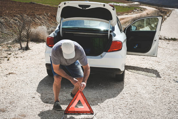 man stands by a broken car - stranded travel people traveling disappointment - fotografias e filmes do acervo