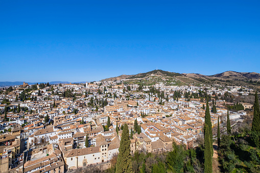Evening city landscape with white houses and tiled roofs against the sky. Granada, Spain.