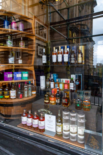 Edinburgh's Royal Mile Whisky shop Royal Mile, Edinburgh, Scotland, August 2023. This is the Royal Mile early morning during the Edinburgh Fringe Festival.  A window display in a Whisky shop. bowmore whisky stock pictures, royalty-free photos & images