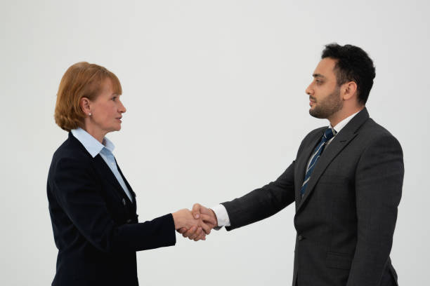 A diverse team of professionals engaging in a teamwork handshake, symbolizing partnership and agreement.