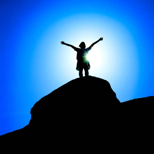 istock Hiker Silhouette Standing on a Mountain Peak 2063331689