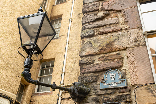 Edinburgh, Scotland, August 2023. This is an alleyway with a streetlight in Edinburgh during the Fringe Festival with a sign Gladstone's Land.