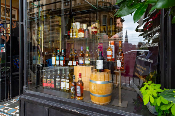 Edinburgh's Royal Mile Whisky shop Royal Mile, Edinburgh, Scotland, August 2023. This is the Royal Mile early morning during the Edinburgh Fringe Festival.  A window display in a Whisky shop. bowmore whisky stock pictures, royalty-free photos & images