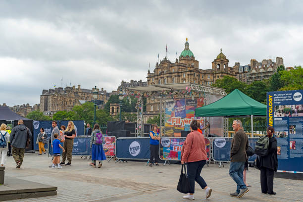 Edinburgh, Scotland, August 2023. This is early morning during the Edinburgh Fringe Festival.  There are tourists on the street looking at posters for the events.