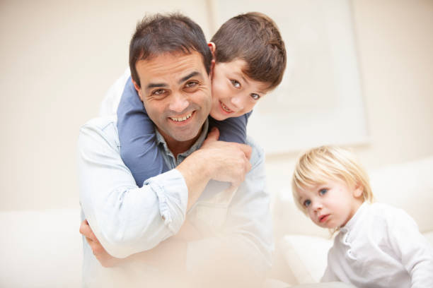 Portrait narrow vertical shot of smiling three generations of men in row line isolated on white studio background. Happy small boy child with young father and old grandfather show unity bonding.