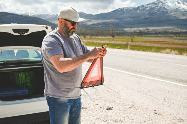 man stands by a broken car - stranded travel people traveling disappointment - fotografias e filmes do acervo