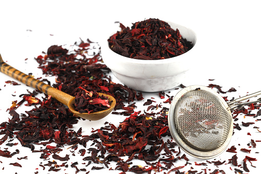 Dry hibiscus tea and sieve on white background. Selective Focus