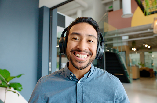 Man, headphones and happy in portrait at startup with streaming, subscription and sound in office. Person, smile and music for inspiration, listening and creativity in workplace at media agency