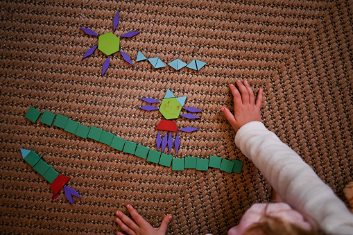 child playing with wooden puzzle shapes.