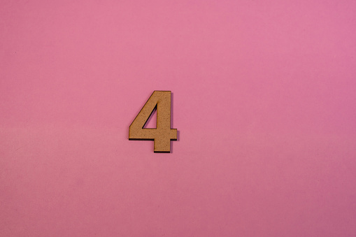 Number 4 in wood on a pink background