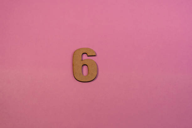istock Number 6 in wood on a pink background 2063374625