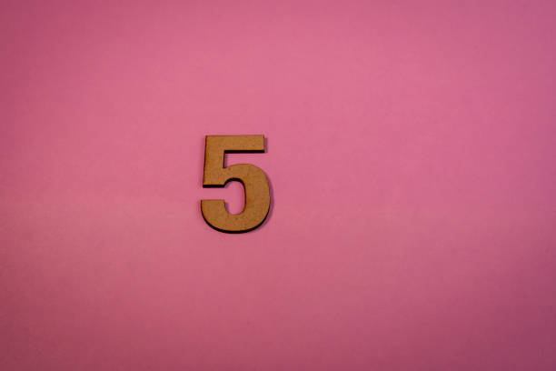 Number 5 in wood on a pink background