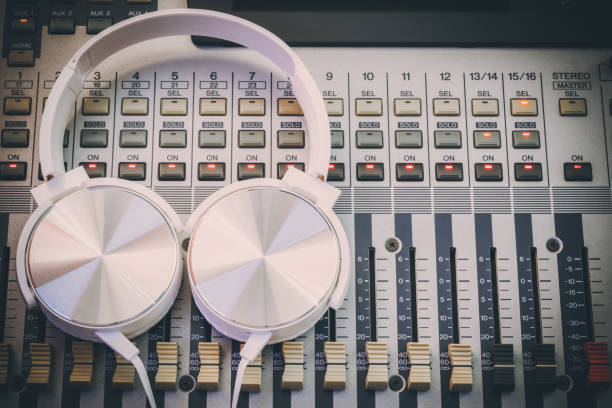 istock white headphone on audio mixing console. music background, recording concept 2063403691