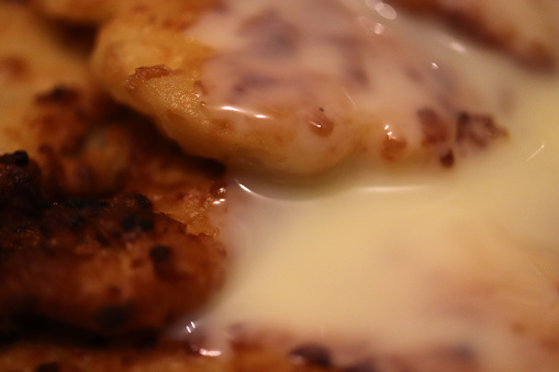 Fried pancakes sprinkled with condensed milk. Delicious background.