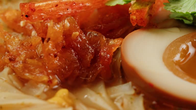 Asian fast food noodles with soybean sprouts, parsley and pickled or century egg close-up. Cooking instant noodles in boiling water with spices. Instant noodles, or instant ramen, is a type of food consisting of noodles sold in a precooked and dried block