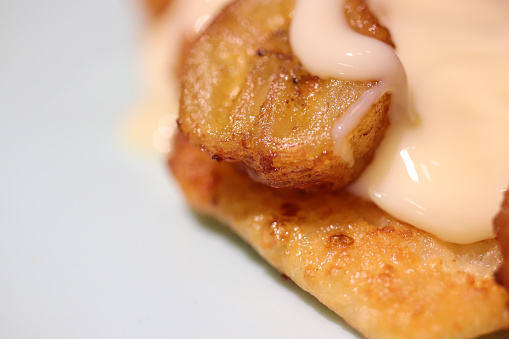 Fried cheesecakes sprinkled with condensed milk and grilled bananas. Delicious background. Macro closeup.