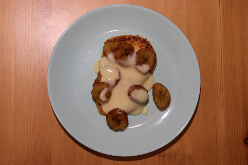 Fried cheesecakes sprinkled with condensed milk and grilled bananas